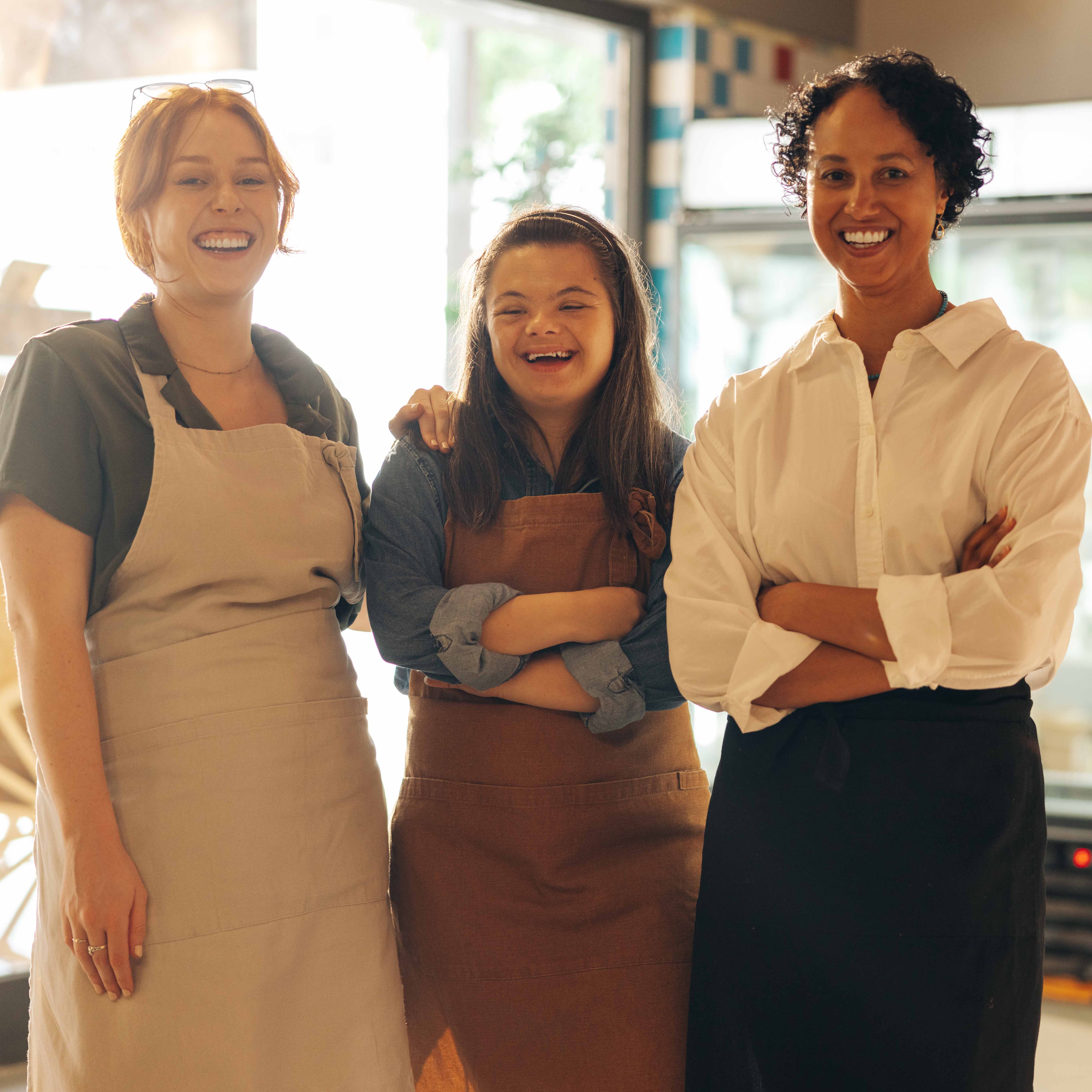 Group of diverse retail workers smiling happily in a grocery store alt="Group of diverse store workers"